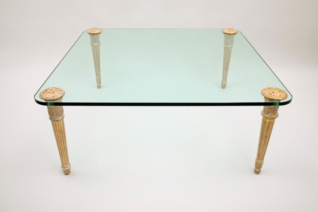 Table basse dorée avec un verre dessus