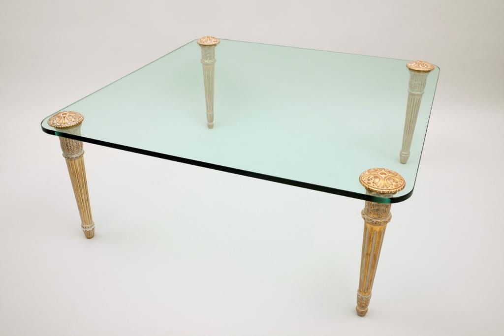 Table basse dorée avec un verre dessus